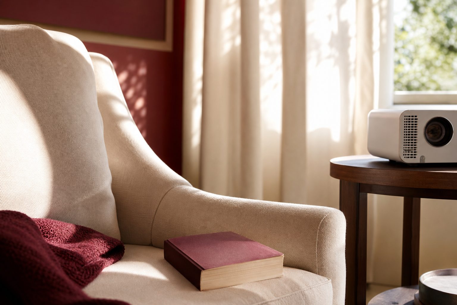 Paperback novel on a cream armchair beside a small projector in a sunlit sitting room